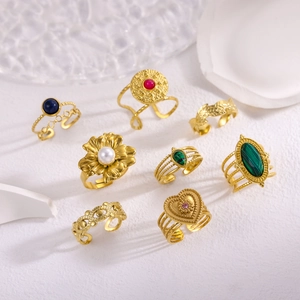 Set of 8 vintage gold metal rings with floral designs, pearls, and colorful gemstones