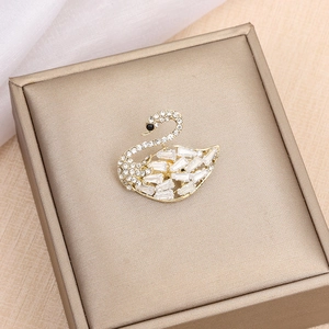 Elegant gold swan brooch featuring sparkling cubic zirconia crystals on jewelry box