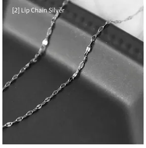 Detail shot of silver lip chain necklace with high metallic luster on dark display stand