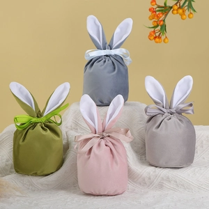 Close-up of velvet Easter bunny ear gift bags with satin ribbons in Morandi colors