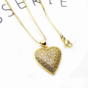 Macro shot of micro-paved heart pendant necklace with zircon and gold-plated box chain