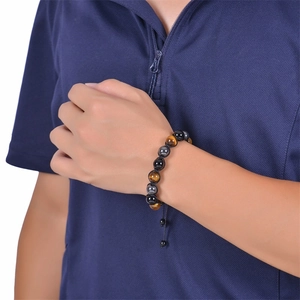 Tiger eye and obsidian beaded bracelet with adjustable woven rope on a male wrist
