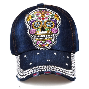 Detail of rhinestone brim and skull embroidery on dark blue denim baseball cap