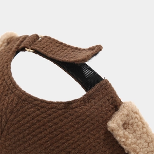 Detail of adjustable Velcro strap with metal ring on brown textured winter docker hat
