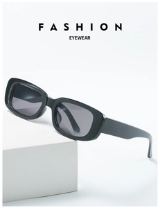 Macro shot of stylish black rectangular sunglasses with glossy finish on a white stand