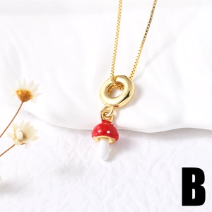 Detail of red enamel mushroom pendant with golden box chain on white background
