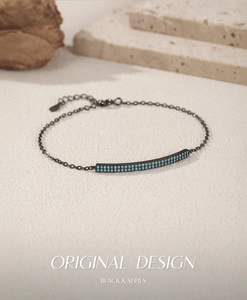 Detail of black metal chain bracelet featuring dual-row turquoise bead inlay on minimalist bar