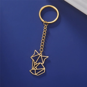 Golden geometric fox charm keychain with metal chain on dark blue background