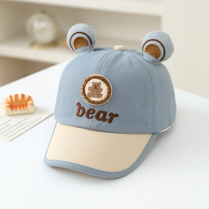 Detail of baby baseball cap with 3D bear ears and cute embroidery in light blue and beige