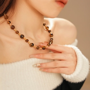 Collana di perle occhio di tigre con dettagli dorati indossata in stile vintage