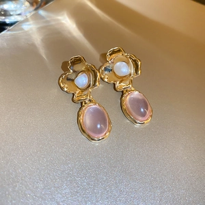 Detail of vintage French style gold metal floral earring with pearl and pink gem