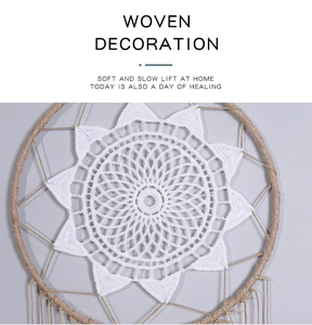 Detailed close-up of woven white crochet dreamcatcher with hanging tassel and hemp rope