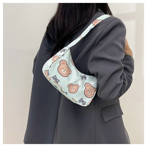 Detailed shoulder view of a light blue underarm bag with cute brown bear and bow patterns