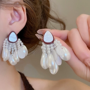 Detail of seashell starfish pearl tassel earrings with cascading white beads for women