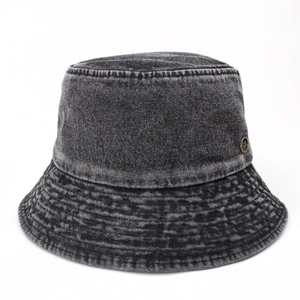 Detailed texture of dark grey washed denim bucket hat with round metal logo and stitching