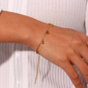 Close-up of gold chain bracelet with colorful square zircon stones on model's wrist