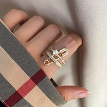 Macro shot of gold safety pin ring with star motif and shimmering zircon pavé