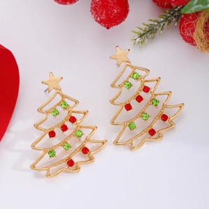 Close-up of golden Christmas tree earrings with colorful rhinestones in a festive setting