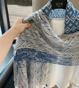 Detail of blue geometric and feather print on lightweight cotton linen beach shawl