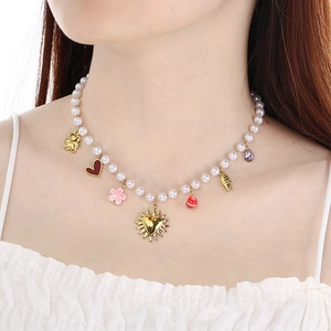 Chic pearl necklace with gold heart and colorful enamel charms worn by a model