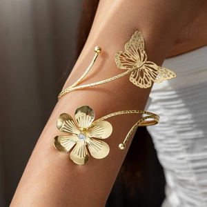 Golden arm cuff with crystal flower and butterfly, elegant hammered metal open wrap design