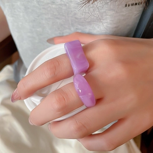Detailed view of purple acrylic resin ring set with marble texture on hand with coffee cup