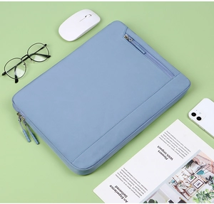 Light blue laptop sleeve with front pocket styled with office accessories on desk