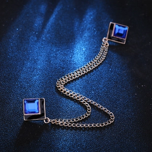Detail of blue square gemstones on golden double-layer chain brooch for collars