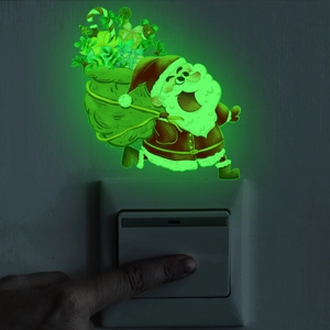 Glow-in-the-dark running Santa Claus sticker with bright green fluorescence on a wall switch