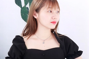 Close-up of a delicate silver heart pendant necklace worn on a woman's neck