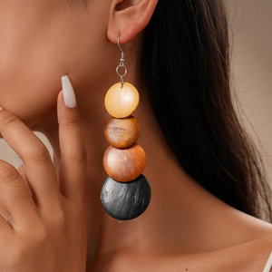 Detail of bohemian long earrings with tiered wooden beads in gradient earth tones