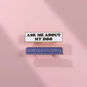 Detail of ASK ME ABOUT MY DOG enamel pins on a soft pink background with shadows