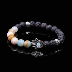 Macro detail of Hamsa Hand charm on lava rock and colorful natural stone beaded bracelet