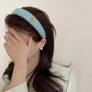 Cerchietto in tweed azzurro con logo in metallo dorato per un look elegante e raffinato