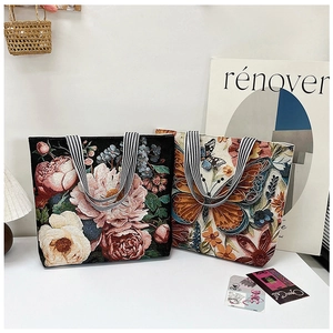Detailed close-up of embroidered butterfly and floral patterns on retro canvas tote bags