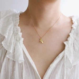 Elegant gold plated titanium steel kitten pendant necklace worn by model on lace shirt
