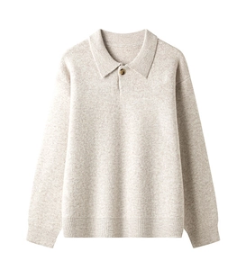 Detailopname van beige gebreide polotrui met fijne textuur en donkerbruine knoop
