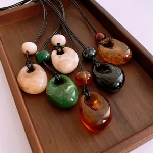 Retro wax rope necklace with water-drop acrylic pendants in emerald and amber colors