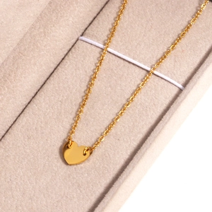 Gros plan d'un collier à pendentif cœur doré dans un écrin de bijoux