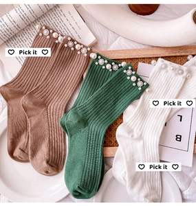Detailed knit texture of mid-calf socks with elegant pearls and silver flower beads