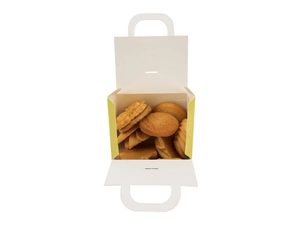 Detail of yellow paper candy gift box with handle and variety of handmade cookies inside