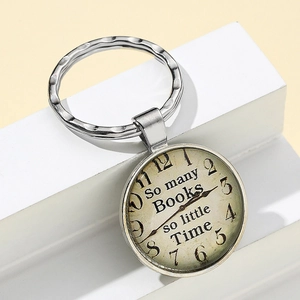Detail of vintage pocket watch keychain with 'So many books so little time' quote