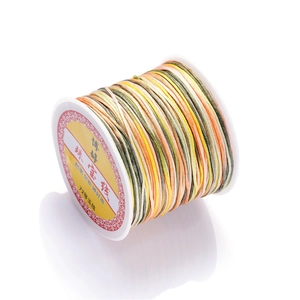 Close-up of size 72 gradient multicolor jewelry cord on a white plastic spool