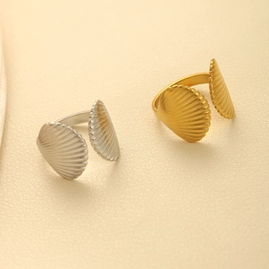 Detailed view of gold and silver shell texture open rings in polished stainless steel