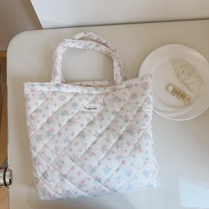 Quilted floral tote bag with pink blossoms and 'simple wish' label in 45-degree view