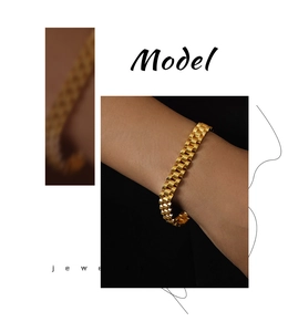 Close-up of a gold geometric watch-strap chain bracelet on a model's wrist