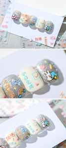 Macro detail of 3D embossed nail stickers featuring cute rabbit and rainbow motifs