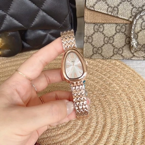 Detailed close-up of a rose gold snake-head watch with scales-style metallic band