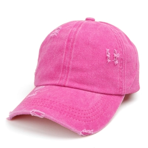 Close-up of rose red washed denim baseball cap featuring distressed holes and retro style