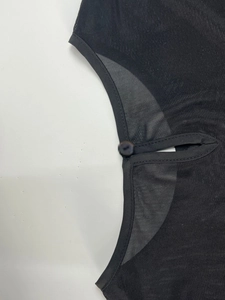 Détail d'un haut en mesh transparent avec découpe goutte d'eau et bouton noir